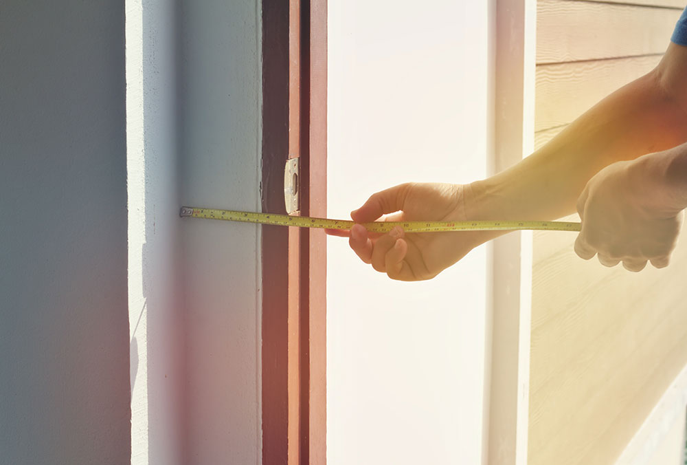 Image of a handyman measuring door width for aging-in-place door-widening