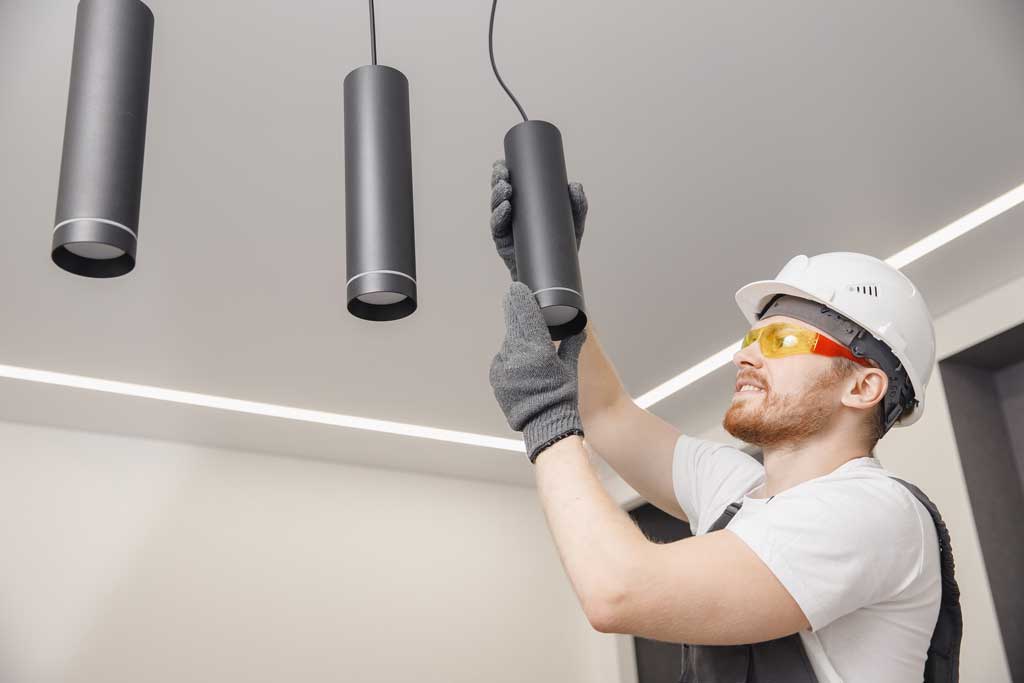 Image of a handyman installing kitchen light fixtures in a kitchen remodel