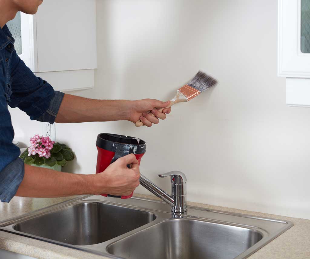 Image of a handyman painting kitchen walls in a kitchen remodel
