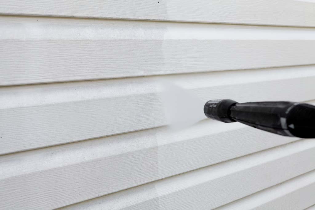 Image of siding being cleaned with a light pressure washer spray