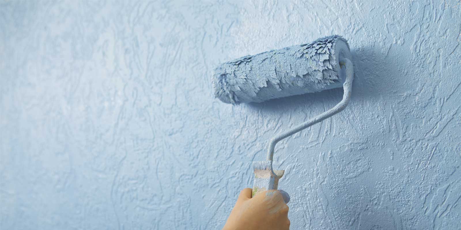 Image of a textured wall being painted with a roller