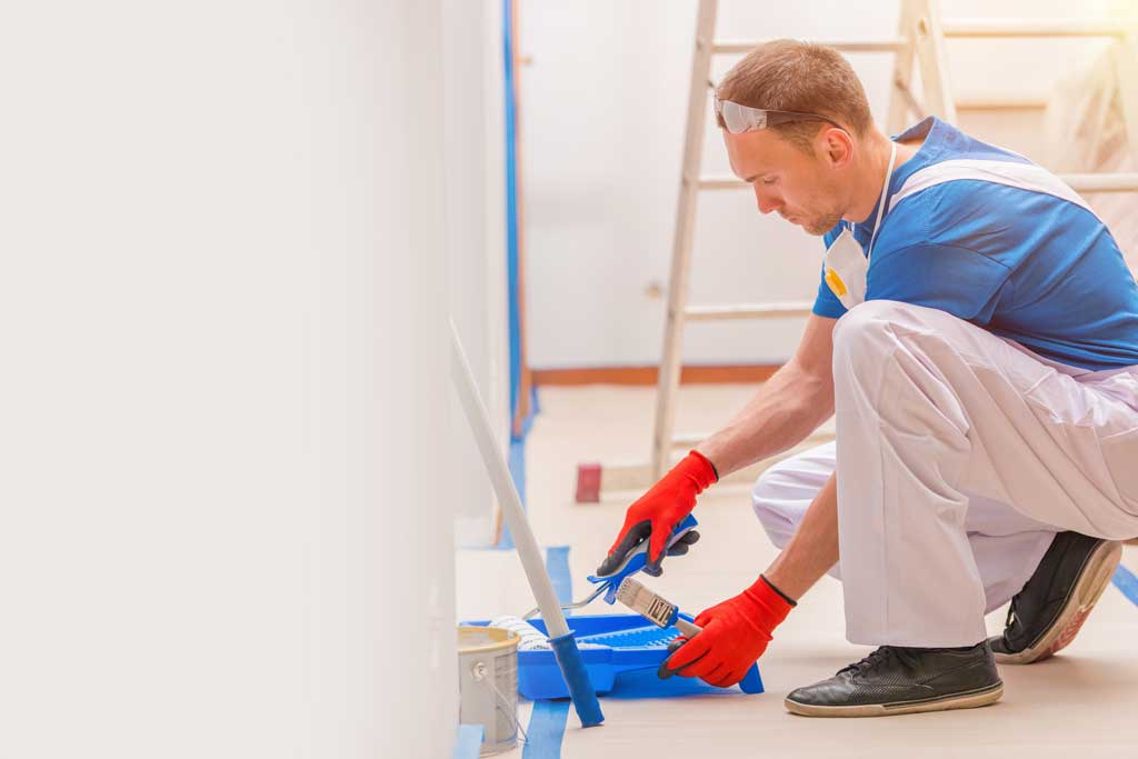Image of a professional painter painting drywall