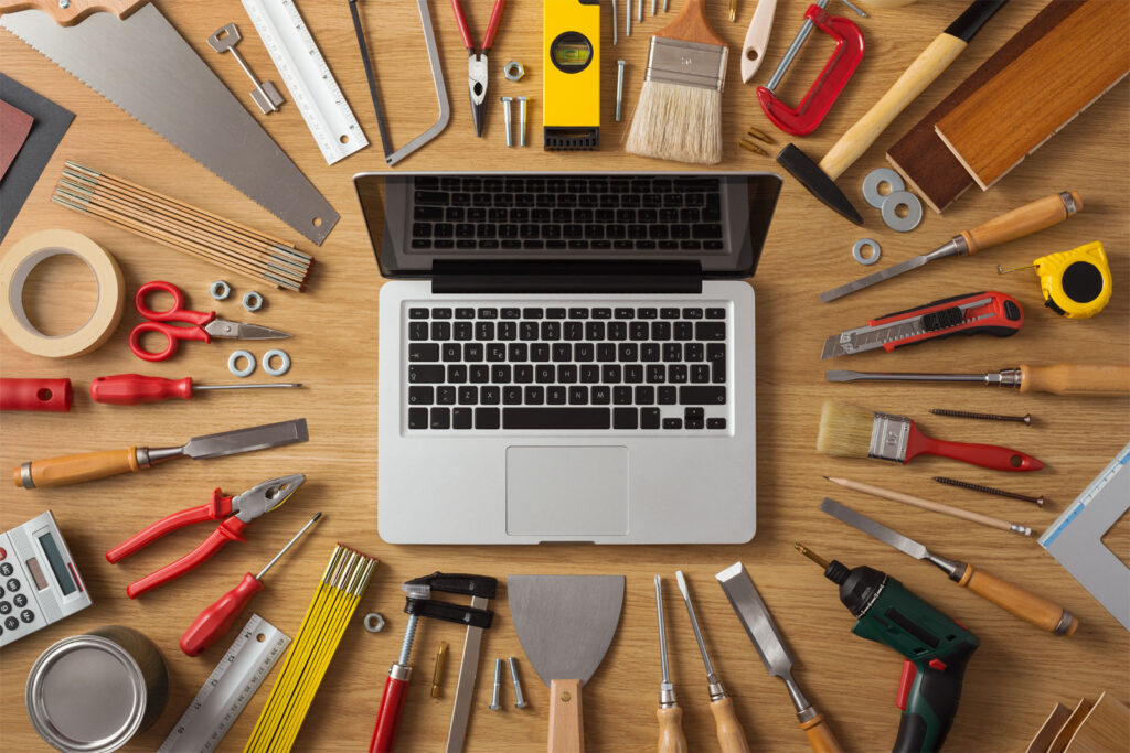Image of laptop on a table surrounded by tools implying do-it-yourself