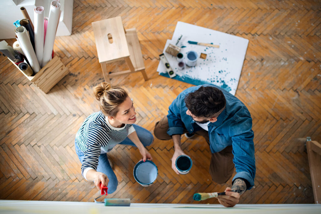 Couple painting interior home wall